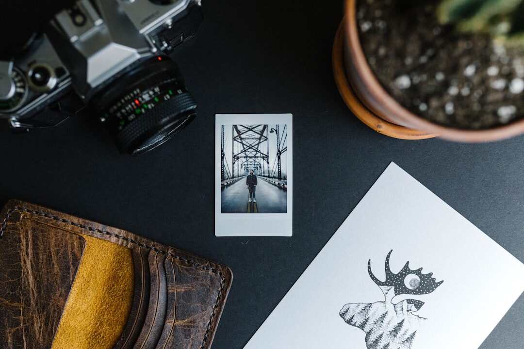 Vintage film camera and printed contact sheets on a wooden desk