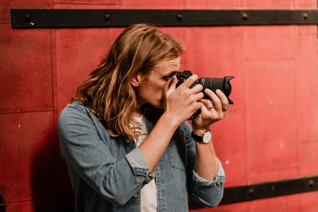Danish female photojournalist holding a camera and looking at viewer